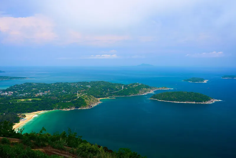 Phuket's southern coast from above: a beach, green headlands and small islands